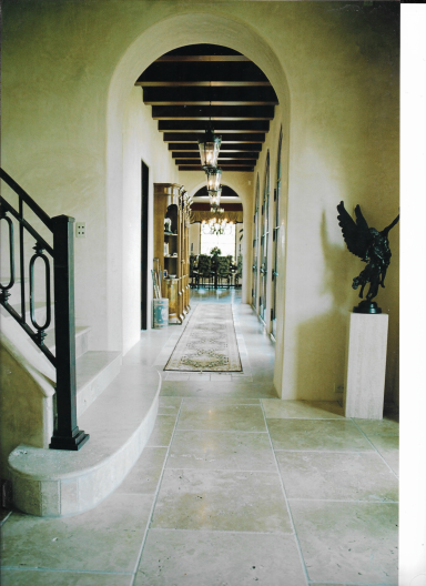 Spacious hallway with arches, stone flooring, and decorative elements.